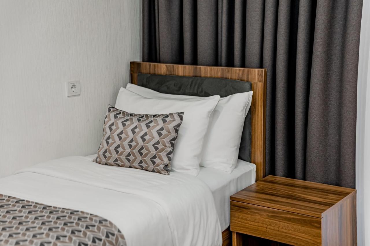 Kutaisi Inn Εξωτερικό φωτογραφία A bed with a throw pillow